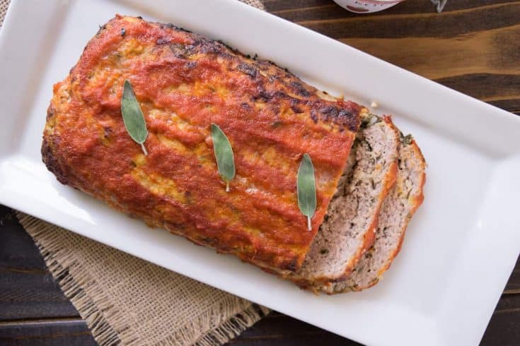A whole pork apple and sage meatloaf on a long white platter