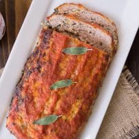 Pork apple and sage meatloaf with some slices on a serving plate