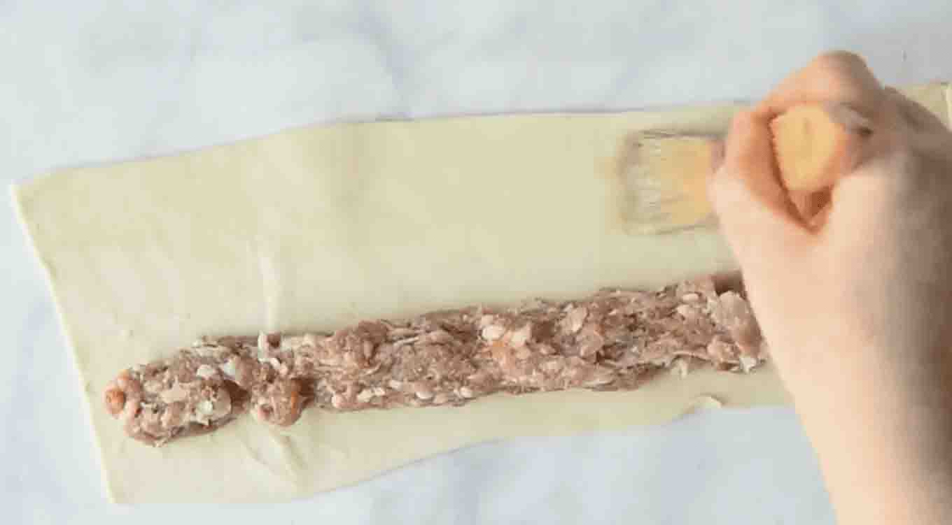 Brushing egg wash onto puff pastry