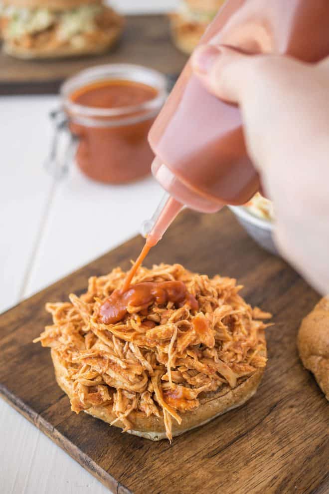 Pouring barbecue sauce on to pulled chicken