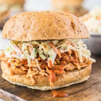 A side view of pulled chicken piled onto a bun and topped with coleslaw