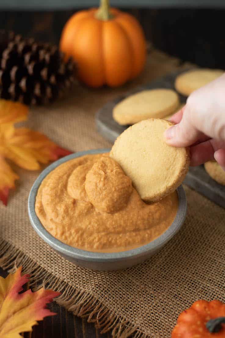 A shortbread cookie being dipped into the dip