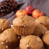 Pumpkin walnut muffins on a rack with 1 on top