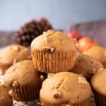 A pumpkin walnut muffin on top of other muffins
