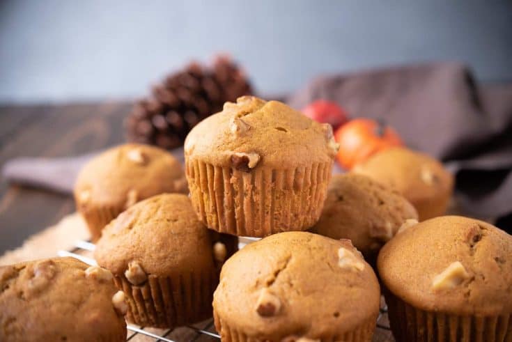 A pumpkin walnut muffin on top of other muffins
