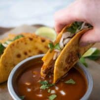 Dipping a quesabirria taco into consomme