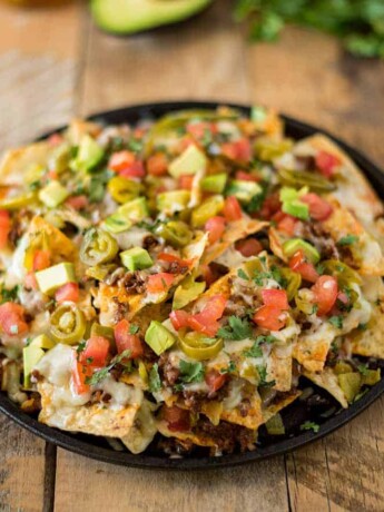 A round pan holding a pile of queso fundido nachos