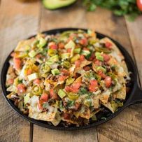 A black cast iron skillet loaded with nachos