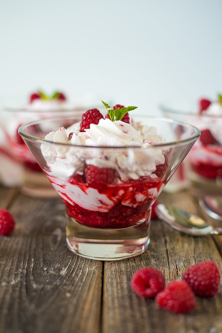 A side image of a raspberry fool in a glass bowl showing the layers of cream and raspberries