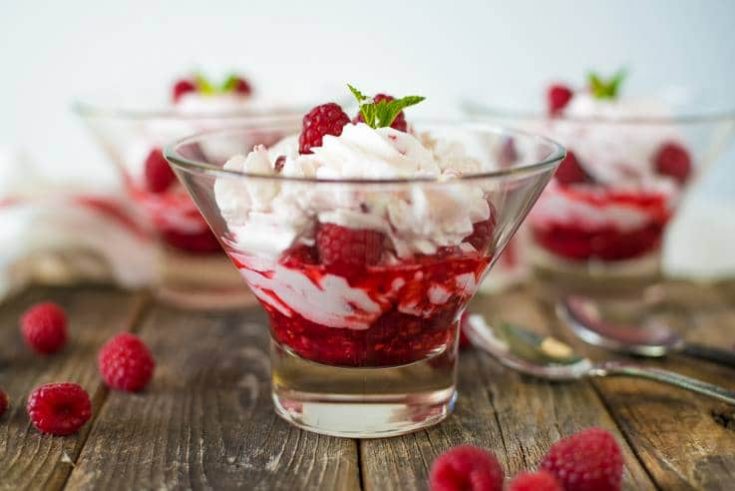 A closeup of the layers of cream and raspberries in a raspberry fruit fool