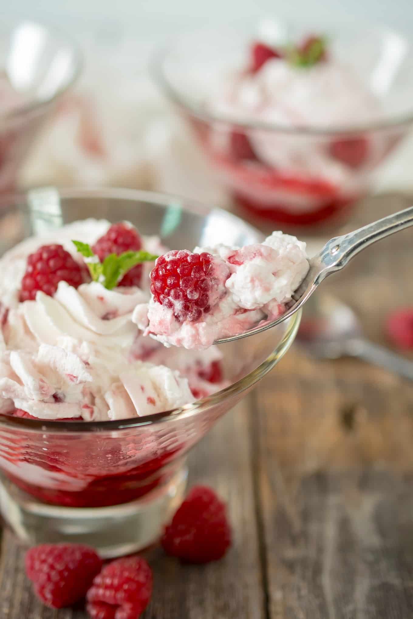 A spoonful of whipped cream and a raspberry