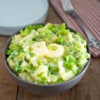 A large bowl of mashed potato mixed with green cabbage, spring onion, Irish cheddar and Irish butter
