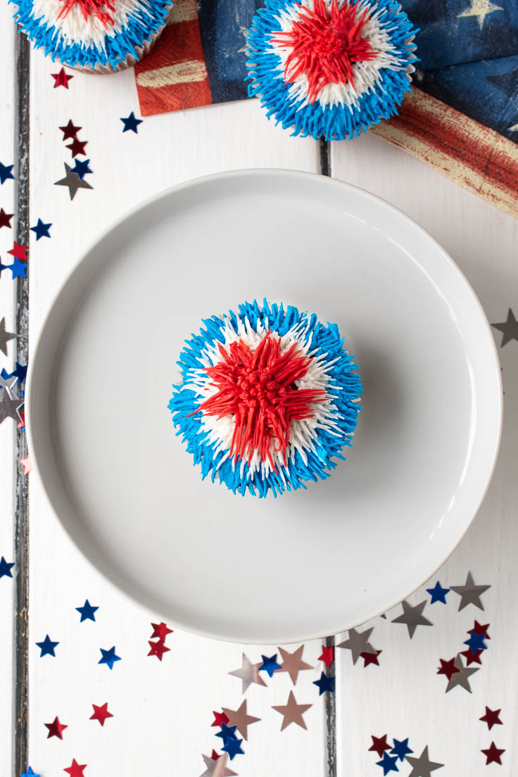 The cupcake from above on a white cake stand with stars