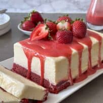 Red velvet cake topped with frozen semifreddo ice cream and strawberry sauce
