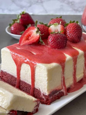 Red velvet cake topped with frozen semifreddo ice cream and strawberry sauce