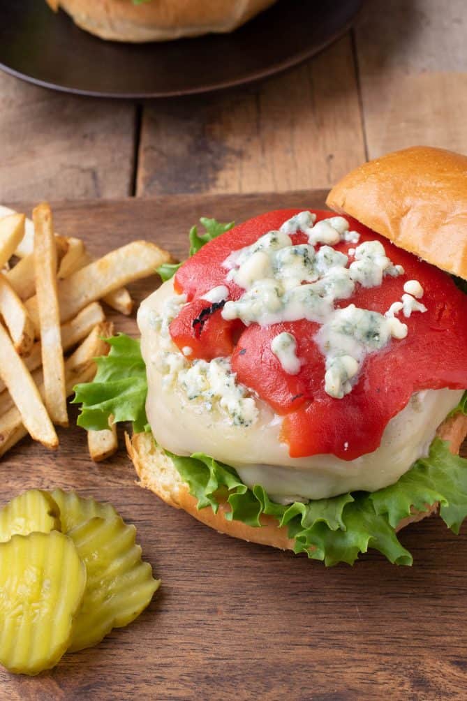 A closeup showing melted blue cheese over the roasted red pepper on top of the burger