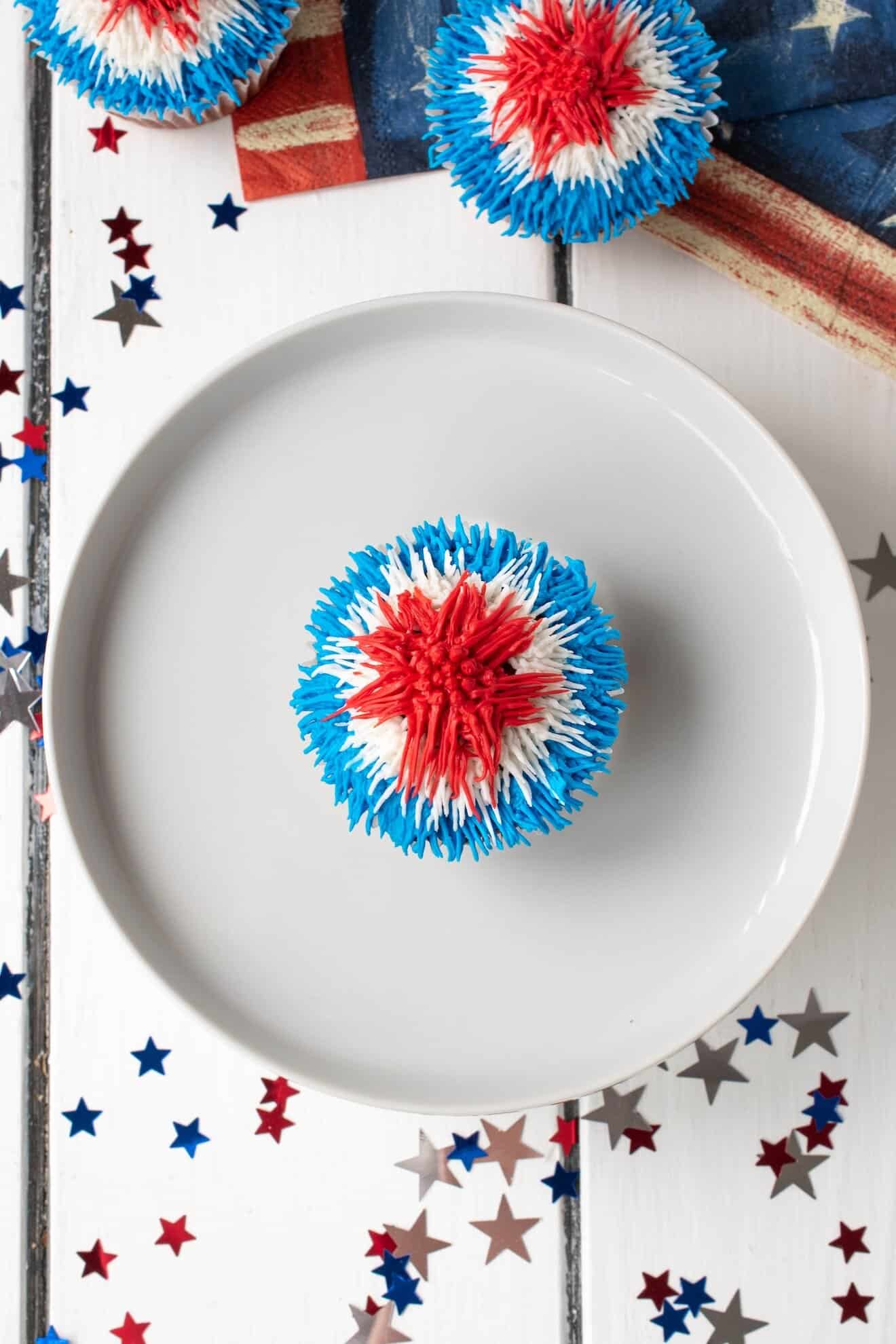 An overhead view of a red white and blue frosted cupcake