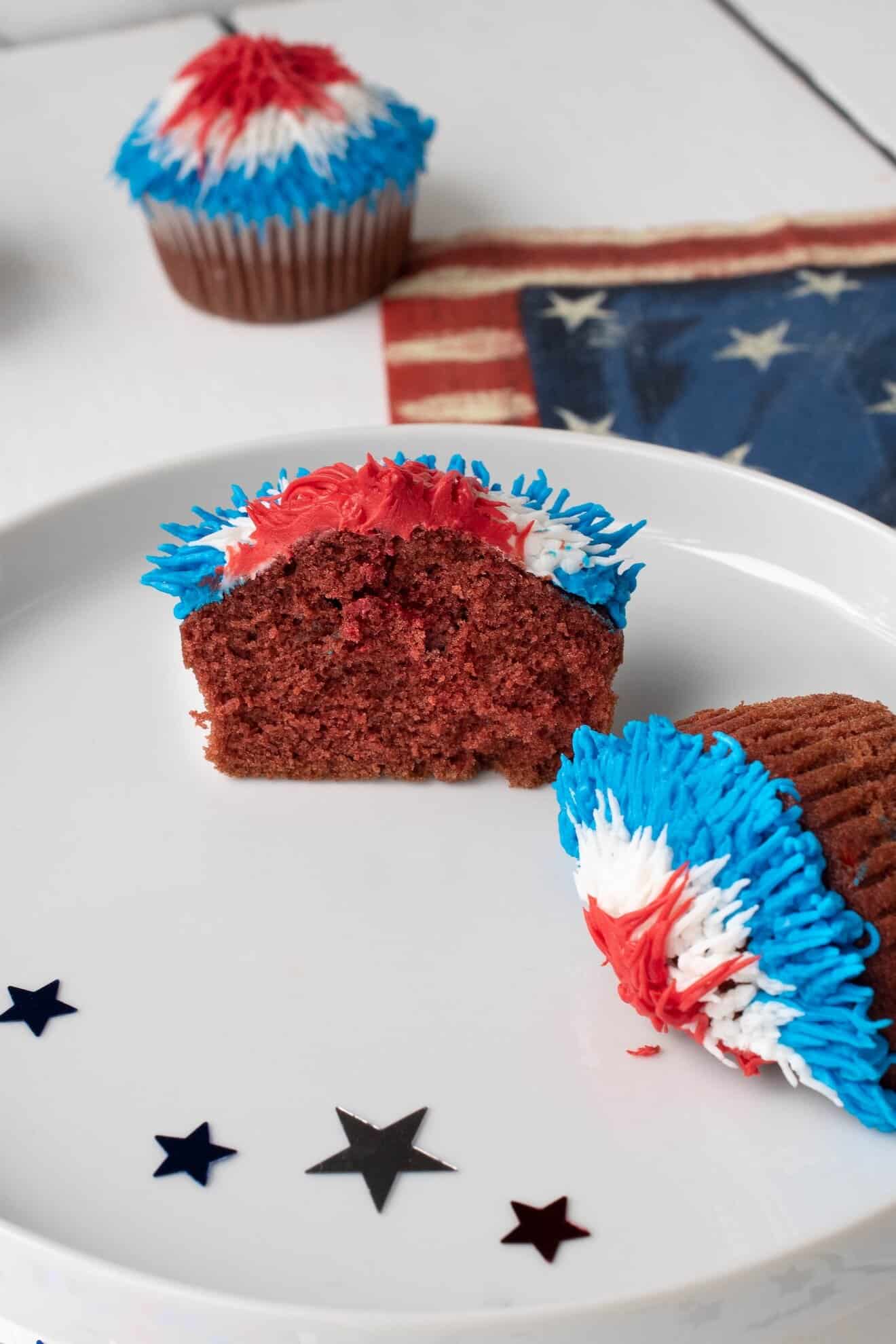 A red velvet cupcake cut in half on a white plate