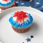 A closeup of a cupcake topped with red, white and blue frosting