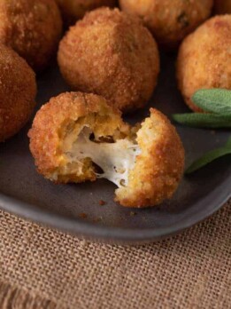 A risotto rice ball opened up to reveal the cheesy center
