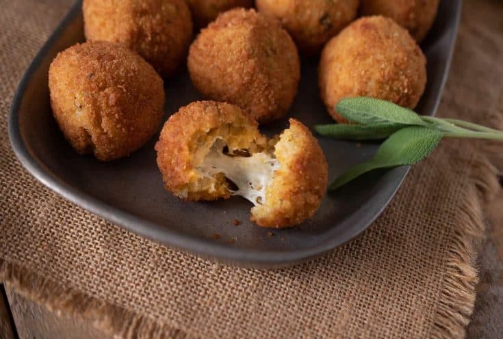 A risotto rice ball opened up to reveal the cheesy center
