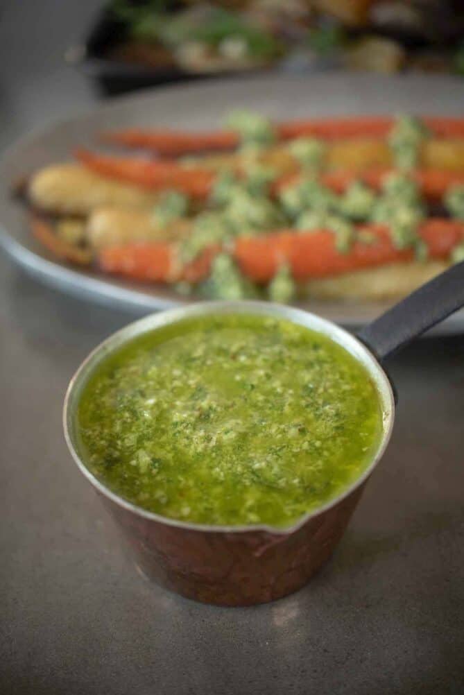 A small copper pan filled with vibrant green spring garlic pesto