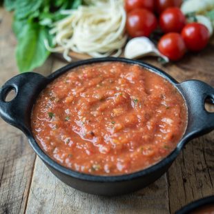 A black bowl filled with fresh tomato sauce