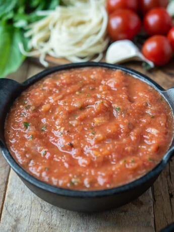 A black bowl filled with fresh tomato sauce