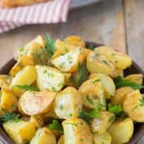 A closeup of the browned potatoes topped with fresh herbs