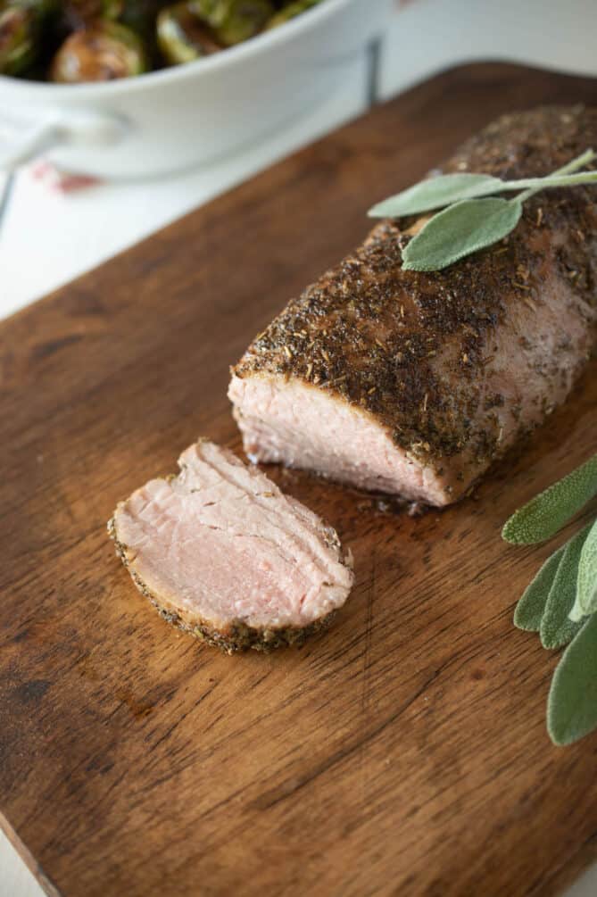A slice of roasted pork tenderloin that is coated in a sage rub.