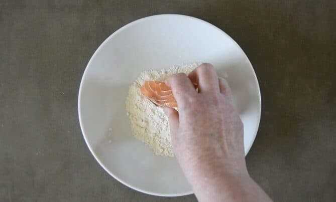 Coating a piece of salmon in flour