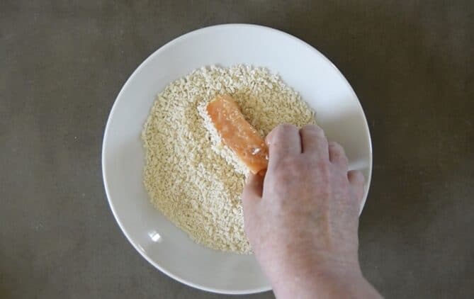 Coating a salmon piece in panko breadcrumbs