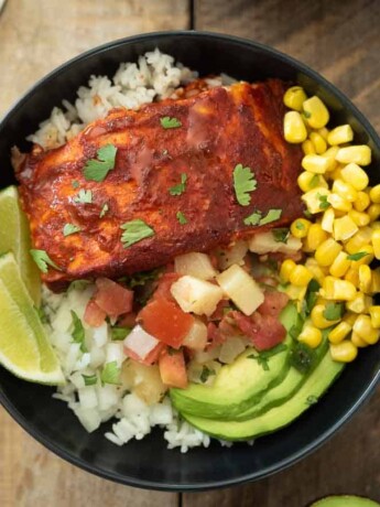 Fresh corn, avocado slices, salsa and salmon in a bowl