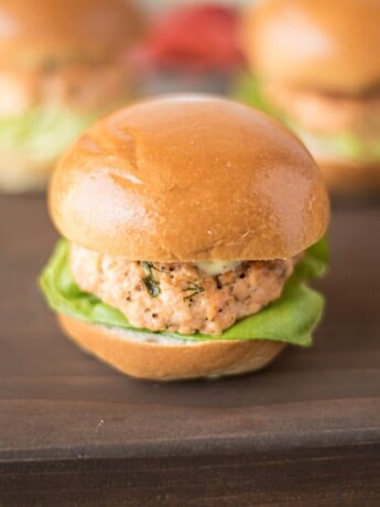 A salmon slider served on a brioche bun with lettuce