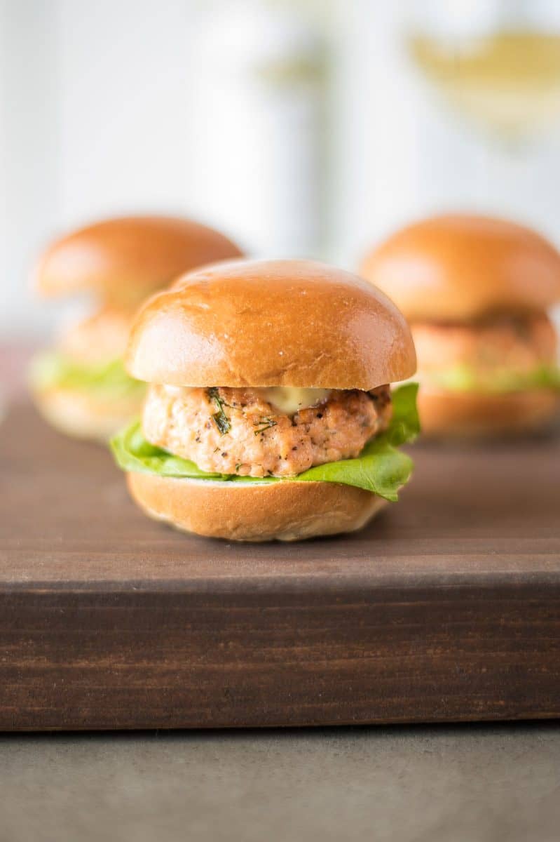 Salmon sliders with caper lemon mayonnaise are delicious, light, summery bites. Fresh salmon is mixed with chives, dill, Dijon mustard and lemon served on mini slider buns and topped with a flavorful mayonnaise.