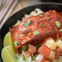Salmon al pastor served with lime wedges and salsa