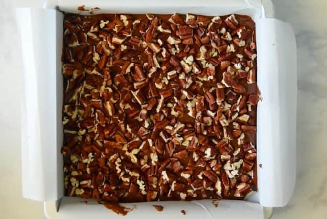 Chopped pecans on top of brownie batter