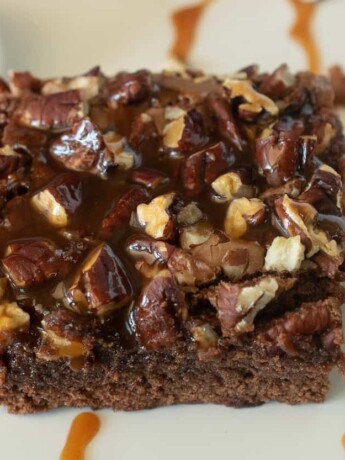 The light hitting the shiny caramel on top of the brownie with caramel drizzles and whipped cream