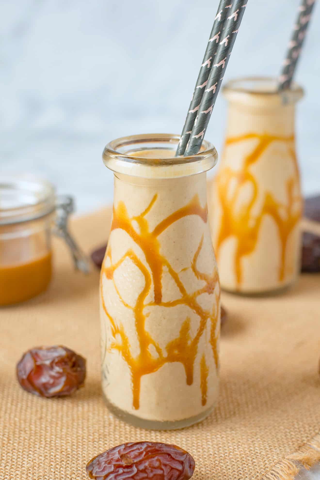 Salted Caramel Date Shake in a glass bottle with straws
