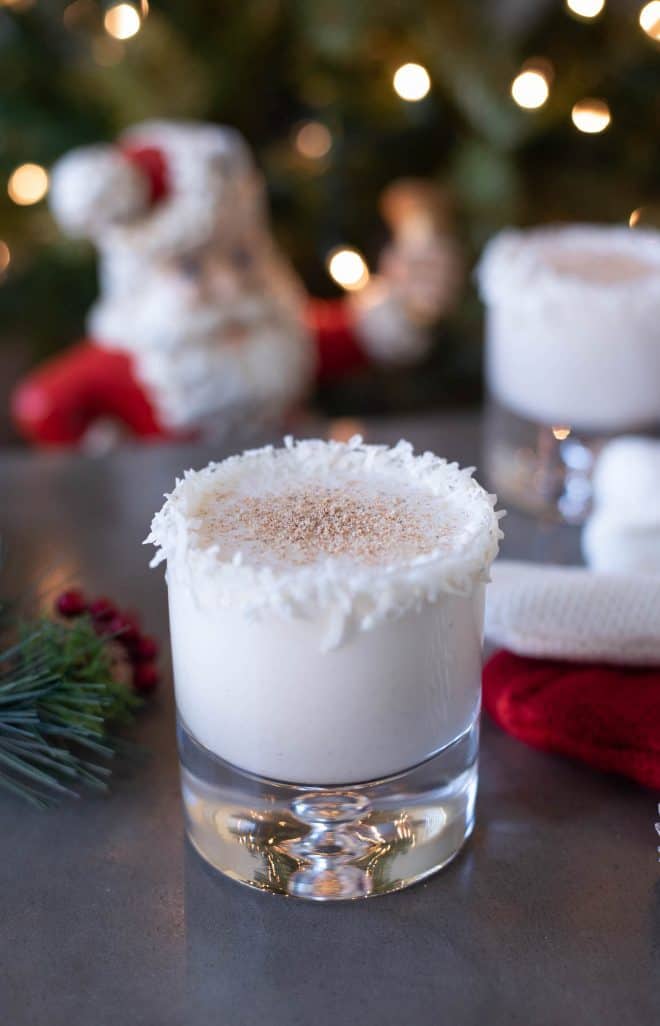 A glass of Santa's Rum Spiked Milk with Santa in the background