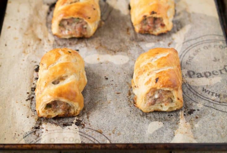 Homemade sausage rolls fresh out of the oven on a baking sheet