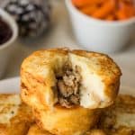 A mashed potato sausage dumpling with some removed showing the sausage stuffing inside