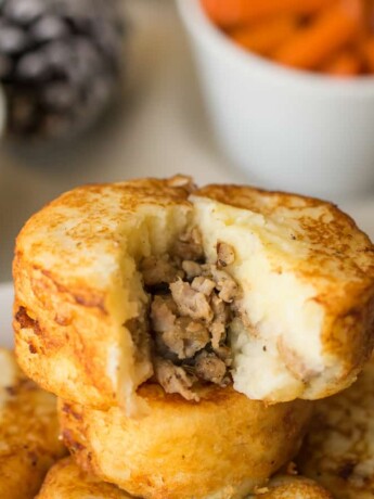 A mashed potato sausage dumpling with some removed showing the sausage stuffing inside