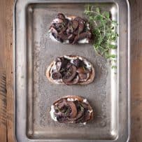 A silver serving tray with sautéed mushroom and rosemary bruschetta