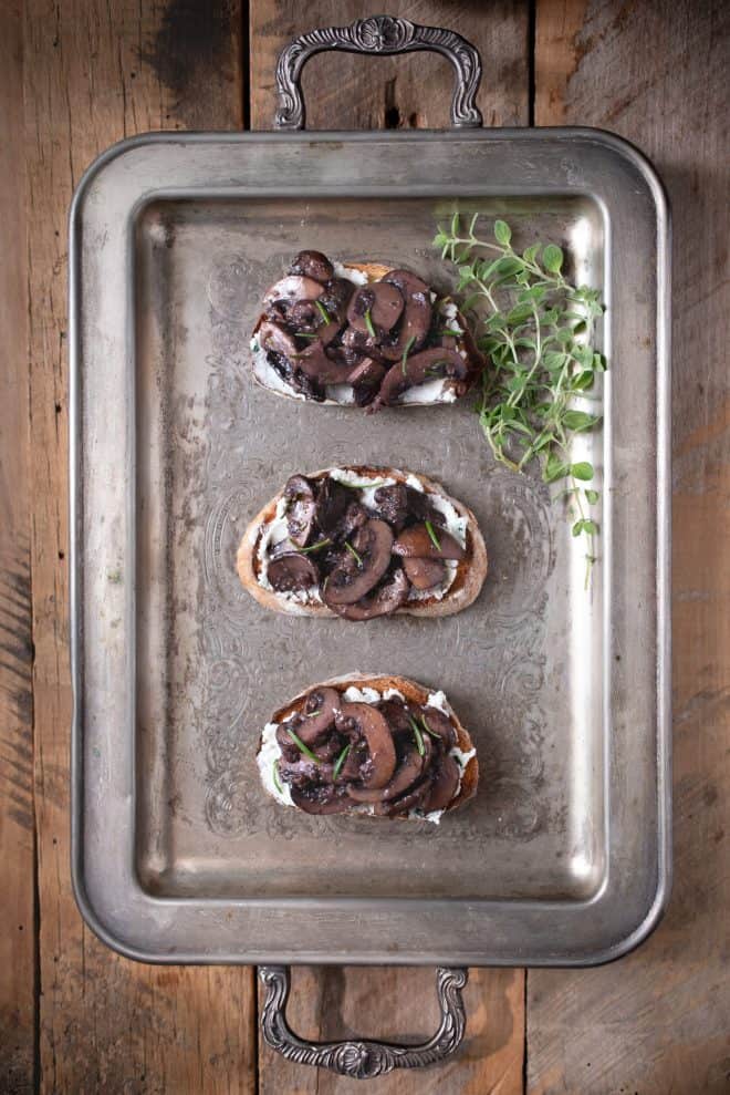 A silver serving tray with sautéed mushroom and rosemary bruschetta