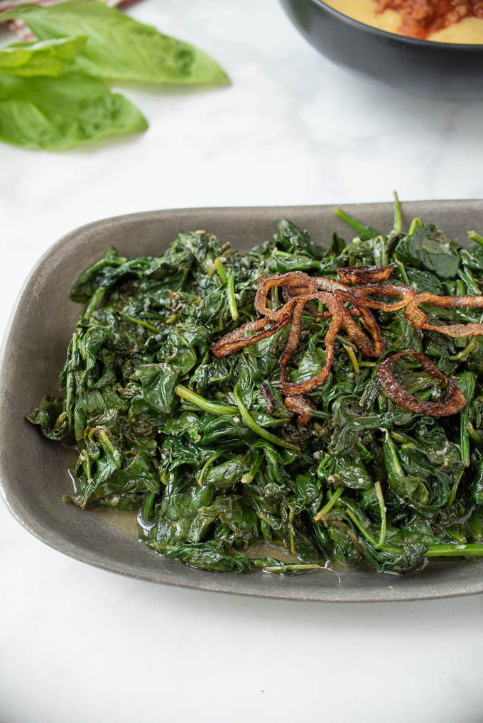 Browned, crispy shallots on top of sauteed spinach