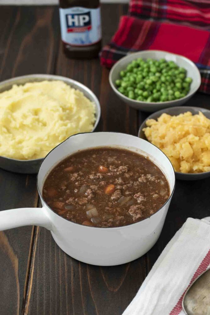 A white pan of minced beef and carrots in gravy