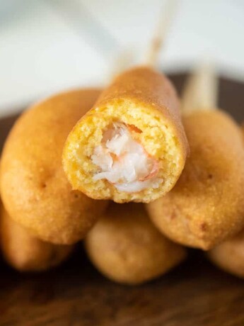 A cut open shrimp corn dog showing the shrimp inside