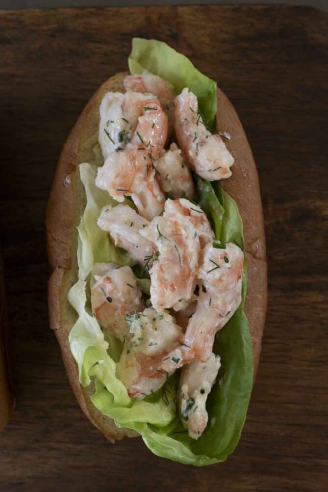 Cooked shrimp mixed with mayonnaise in a bun with lettuce