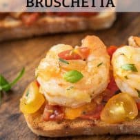 A jumbo shrimp on top of toasted bread with tomatoes